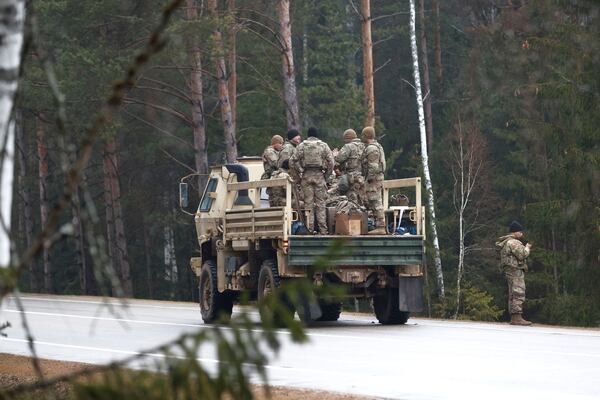 U.S. soldiers stand in the back of a truck on a road towards a training range in Pabrade, north of the capital Vilnius, Lithuania on Thursday, March 27, 2025. (AP Photo/Mindaugas Kulbis)