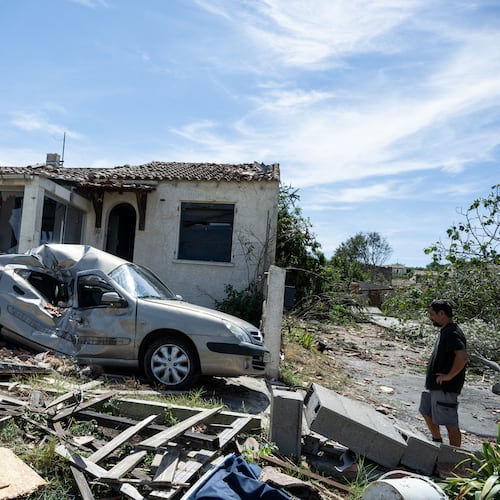 A resident watches a damaged house after a tornado ravaged the small village of Pomas in southern France, leaving dozens injured, Tuesday Aug. 25, 2026. (AP Photo/Frederic Lancelot)