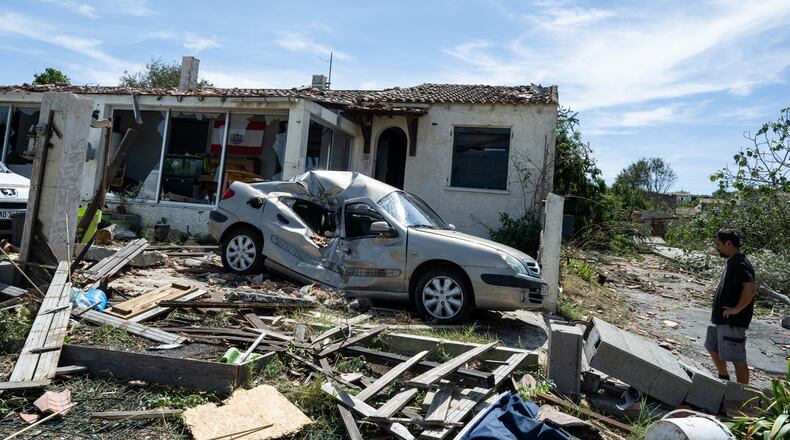 A resident watches a damaged house after a tornado ravaged the small village of Pomas in southern France, leaving dozens injured, Tuesday Aug. 25, 2026. (AP Photo/Frederic Lancelot)