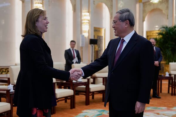 Chinese Premier Li Qiang, right, greets UL Solutions CEO Jennifer Scanlon from a delegation led by U.S. Senator Steve Daines before a meeting held in the Fujian Room at the Great Hall of the People in Beijing, China, Sunday, March 23, 2025. (AP Photo/Ng Han Guan, Pool)