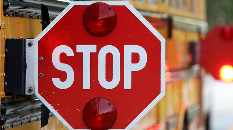 As more travelers pass stopped Cobb school buses, five more county staff positions have been created to handle prosecutions of the violators. AJC file photo