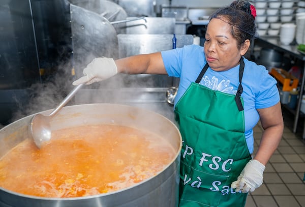 Chef Rith K. Green prepares an enormous pot of bún riêu (crab noodle soup). The soup, native to north Vietnam, is part of the center's Thanksgiving season festivities. (Courtesy of Wes Carter)