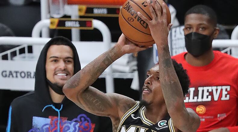 Injured Atlanta Hawks guard Trae Young is all smiles as Lou Williams shoots a three against the Milwaukee Bucks during the fourth quarter in Game 4 of the NBA Eastern Conference Finals on Tuesday, June 29, 2021, in Atlanta. Curtis Compton / Curtis.Compton@ajc.com