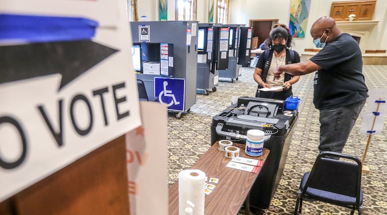 June 21, 2022 Atlanta: With a light morning voter turnout, C. Harper (left) turns in her ballot to poll worker, Michael Bacon (right) at Saint Luke’s Episcopal Church at 435 Peachtree St NE, Atlanta on Tuesday, June 21, 2022. Runoff elections on Tuesday were needed to settle races from the May primary in which no candidate won more than 50% of the vote. The elections were open to registered voters, with a catch. Voters who participated in the primary must have voted in the same party during the primary runoff. Registered voters who skipped the primary can vote in either party’s runoff. Runoff races include a number of legislative and congressional seats, in addition to Democratic runoffs for secretary of state, lieutenant governor, insurance commissioner and labor commissioner. There were also local runoffs in Cherokee, Cobb, DeKalb, Fayette, Gwinnett and Henry counties. The general election is Nov. 8. (John Spink / John.Spink@ajc.com)