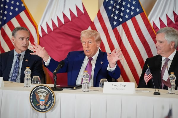 President Donald Trump speaks, seated between Kelly Ortberg President and CEO of Boeing, left, and Larry Culp, CEo of GE Aerospace during a business roundtable, Thursday, May 15, 2025, in Doha, Qatar. (AP Photo/Alex Brandon)