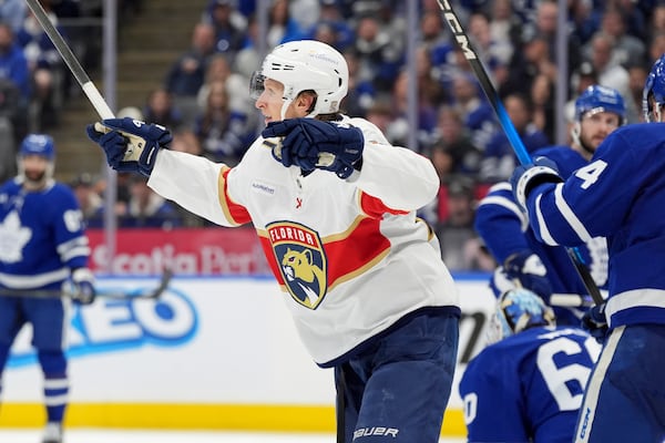 Florida Panthers centre Eetu Luostarinen, center, celebrates after scoring against Toronto Maple Leafs goaltender Joseph Woll (60) during the third period of Game 7 of a second-round NHL hockey playoff series in Toronto, Sunday, May 18, 2025. (Frank Gunn/The Canadian Press via AP)