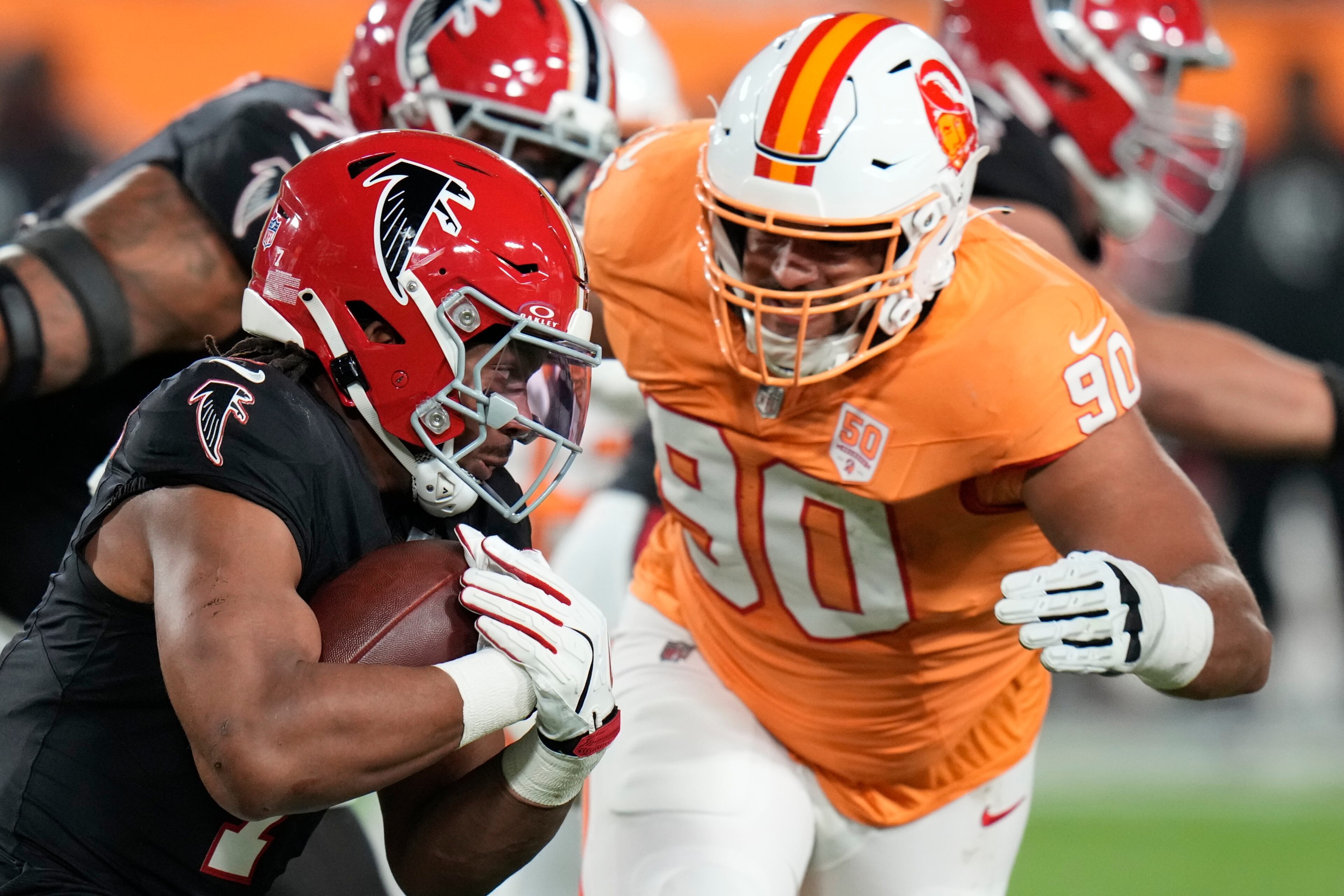 Atlanta Falcons running back Bijan Robinson (7) runs against Tampa Bay Buccaneers defensive end Logan Hall (90) during the first half of an NFL football game, Thursday, Dec. 11, 2025, in Tampa, Fla. (AP Photo/Chris O'Meara)