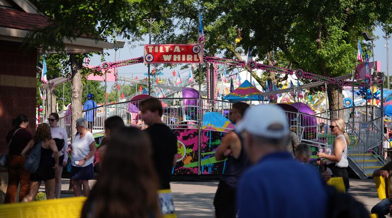 Fairgoers pass the Tilt-A-Whirl, Thursday, Aug. 27, 2026, at the Minnesota State Fair in Falcon Heights, Minn. (AP Photo/Ellen Schmidt)