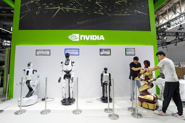 In this photo released by Xinhua News Agency, workers set up a robot at the booth of Nvidia ahead of the upcoming third China International Supply Chain Expo (CISCE) in Beijing, on July 14, 2025. (Ju Huanzong/Xinhua via AP)