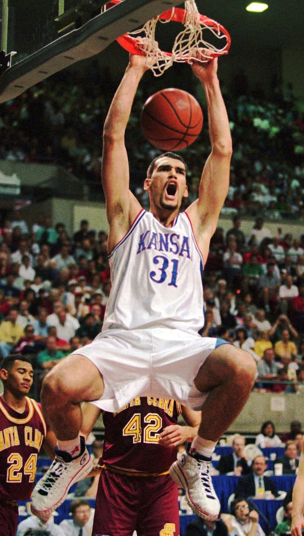 FILE - Kansas center Scot Pollard slam dunks against Santa Clara during the first half of their second round NCAA West Regional game Sunday, March 17, 1996, in Tempe, Ariz. Behind Pollard are Santa Clara's Brendan Graves (42) and Marlon garnett (24). (AP Photo/Jeff Robbins, File)