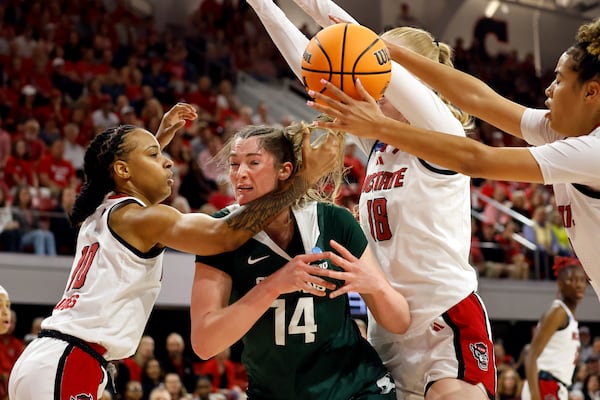 Michigan State's Grace VanSlooten (14) looses control of the ball between North Carolina State's Aziaha James (10), Tilda Trygger (18), and Madison Hayes, right, during the first half in the second round of the NCAA college basketball tournament in Raleigh, N.C., Monday, March 24, 2025. (AP Photo/Karl DeBlaker)
