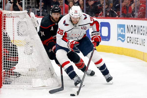 Washington Capitals' Nic Dowd (26) controls the puck in front of Carolina Hurricanes' Jaccob Slavin (74) during the first period of Game 3 of an NHL hockey Semi-final round playoff series in Raleigh, N.C., Saturday, May 10, 2025. (AP Photo/Karl DeBlaker)