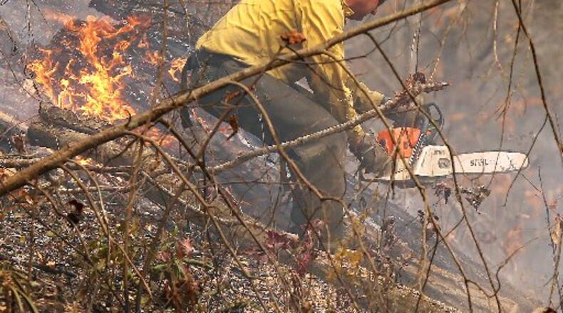 November 15, 2016, Clayton: A Billings, Montana firefighter works the Rock Mountain Fire along Old Coleman River Road to keep the fire from jumping the road on Tuesday, Nov. 15, 2016, near Clayton. Curtis Compton/ccompton@ajc.com