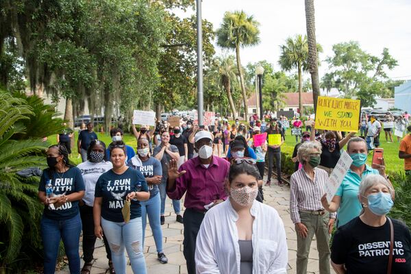 FILE - Demonstrators hold signs as they rally for Ahmaud Arbery in Brunswick on June 4, 2020.(ALYSSA POINTER / ALYSSA.POINTER@AJC.COM)