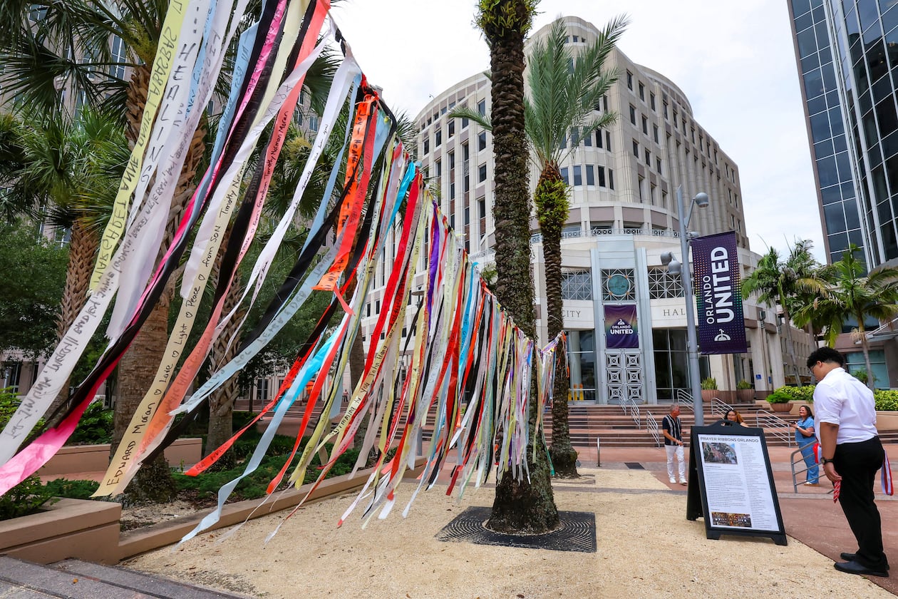 A person reads about the prayer ribbons honoring those killed in the 2016 Pulse nightclub shooting at Orlando City Hall, in Orlando, Fla., Tuesday, June 9, 2026. (Joe Burbank/Orlando Sentinel via AP)