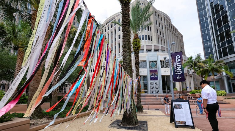 A person reads about the prayer ribbons honoring those killed in the 2016 Pulse nightclub shooting at Orlando City Hall, in Orlando, Fla., Tuesday, June 9, 2026. (Joe Burbank/Orlando Sentinel via AP)