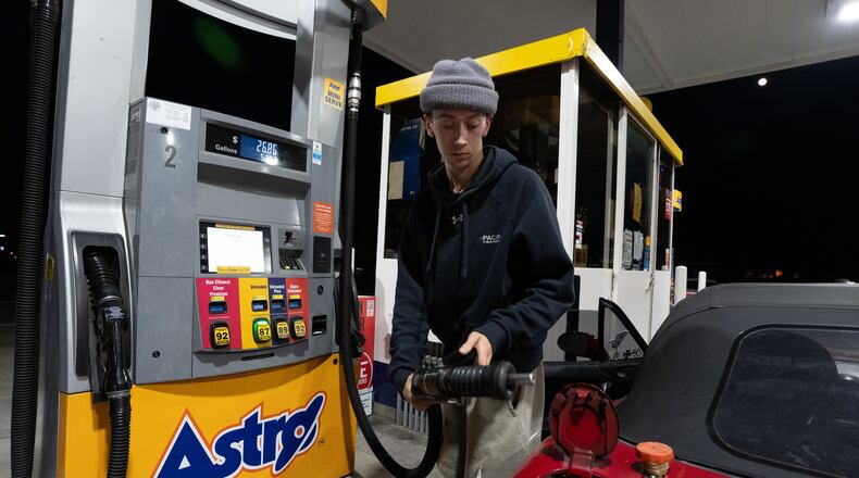 Luciano V. replaces the fuel nozzel after filling the tank of their 1999 Mazda Miata at an Astro gas station on Wednesday, April 29, 2026, in Portland, Ore. (AP Photo/Jenny Kane)