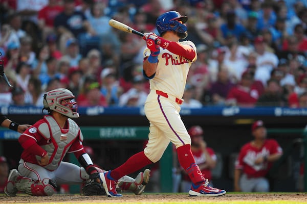 Philadelphia Phillies' Kyle Schwarber, right, watches his two-run home run off Cincinnati Reds pitcher Brent Suter during the eighth inning of a baseball game, Saturday, July 5, 2025, in Philadelphia. (AP Photo/Derik Hamilton)
