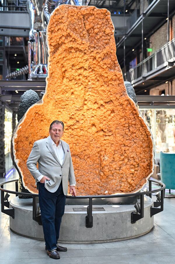Richard C. Kessler in front of one of the largest Citrine geodes in the world inside the JW Marriott Savannah Plant Riverside District lobby. (Sarah Peacock for The Atlanta Journal-Constitution)