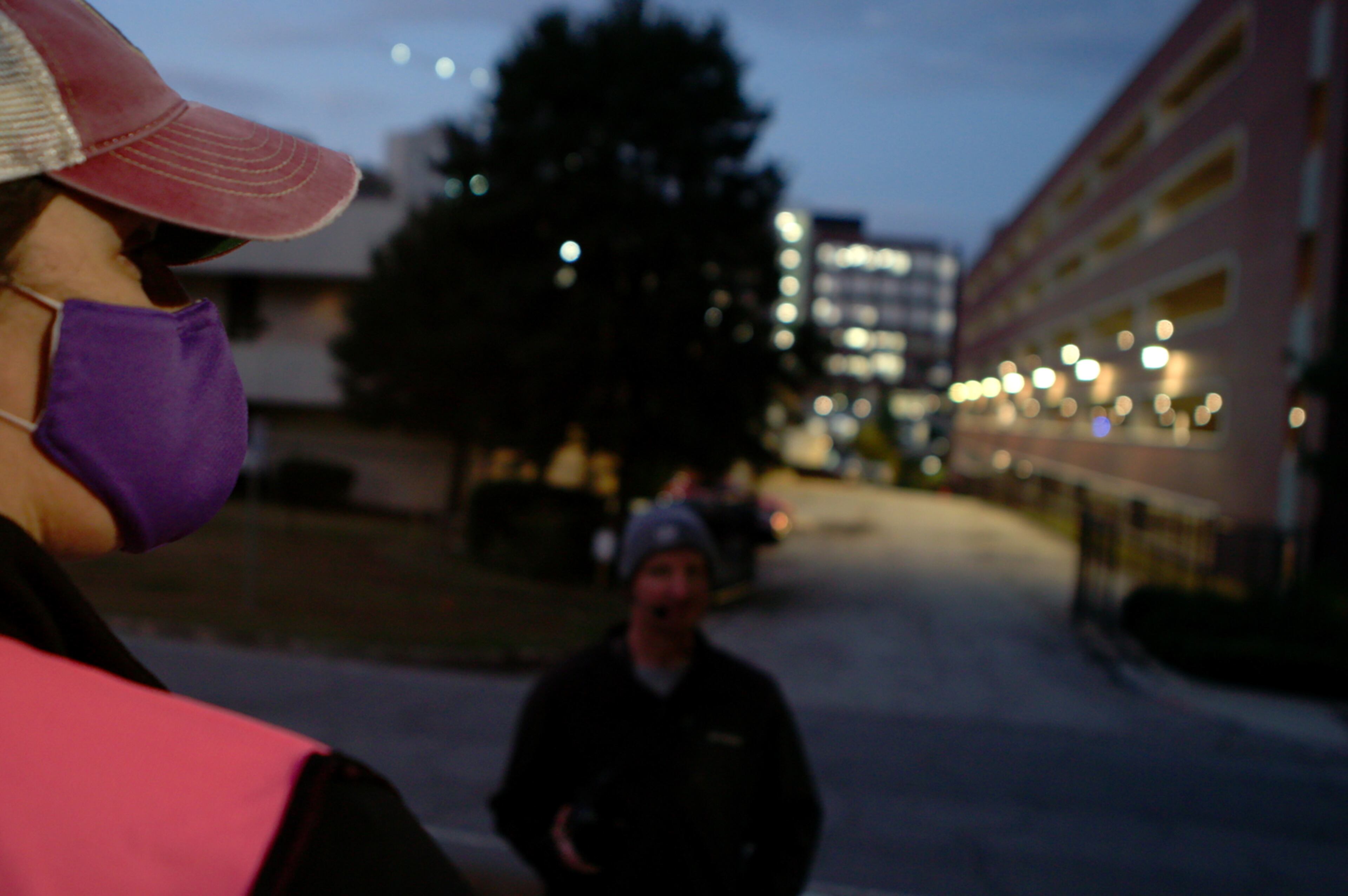 Health care guard waits for patients to enter Atlanta clinic as a protester stands outside facility in "The Devil Is Busy" documentary.
