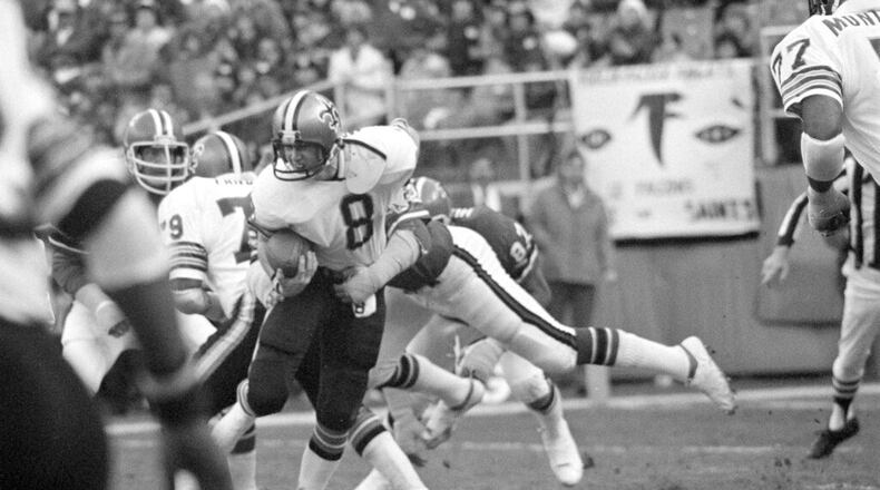 Quarterback Archie Manning (8) of the New Orleans Saints struggles in the clutches of defensive end Claude Humphrey (87) of the Atlanta Falcons in first half action at Atlanta-Fulton County Stadium in Atlanta, Ga., Dec. 18, 1977. Humphrey's tackle dropped Manning near the Saints goal line. (AP Photo/Charles Kelly)