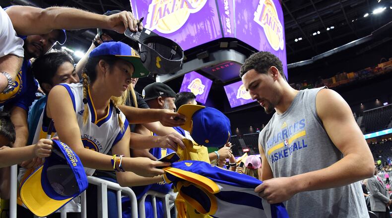 The Golden State Warrior's Klay Thompson signs autographs for young fans.