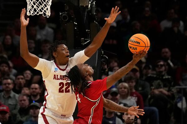 Robert Morris guard Josh Omojafo (4) shoots as Alabama forward Aiden Sherrell (22) defends in the first half in the first round of the NCAA college basketball tournament, Friday, March 21, 2025, in Cleveland. (AP Photo/Sue Ogrocki)