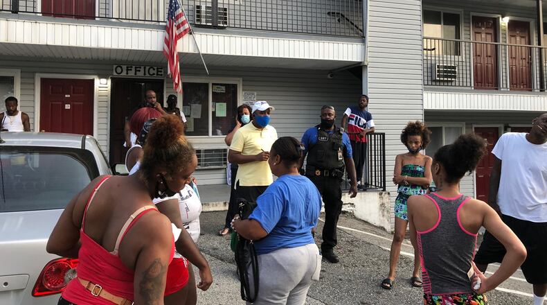 Residents stand outside the Efficiency Lodge in south DeKalb County on Tuesday.