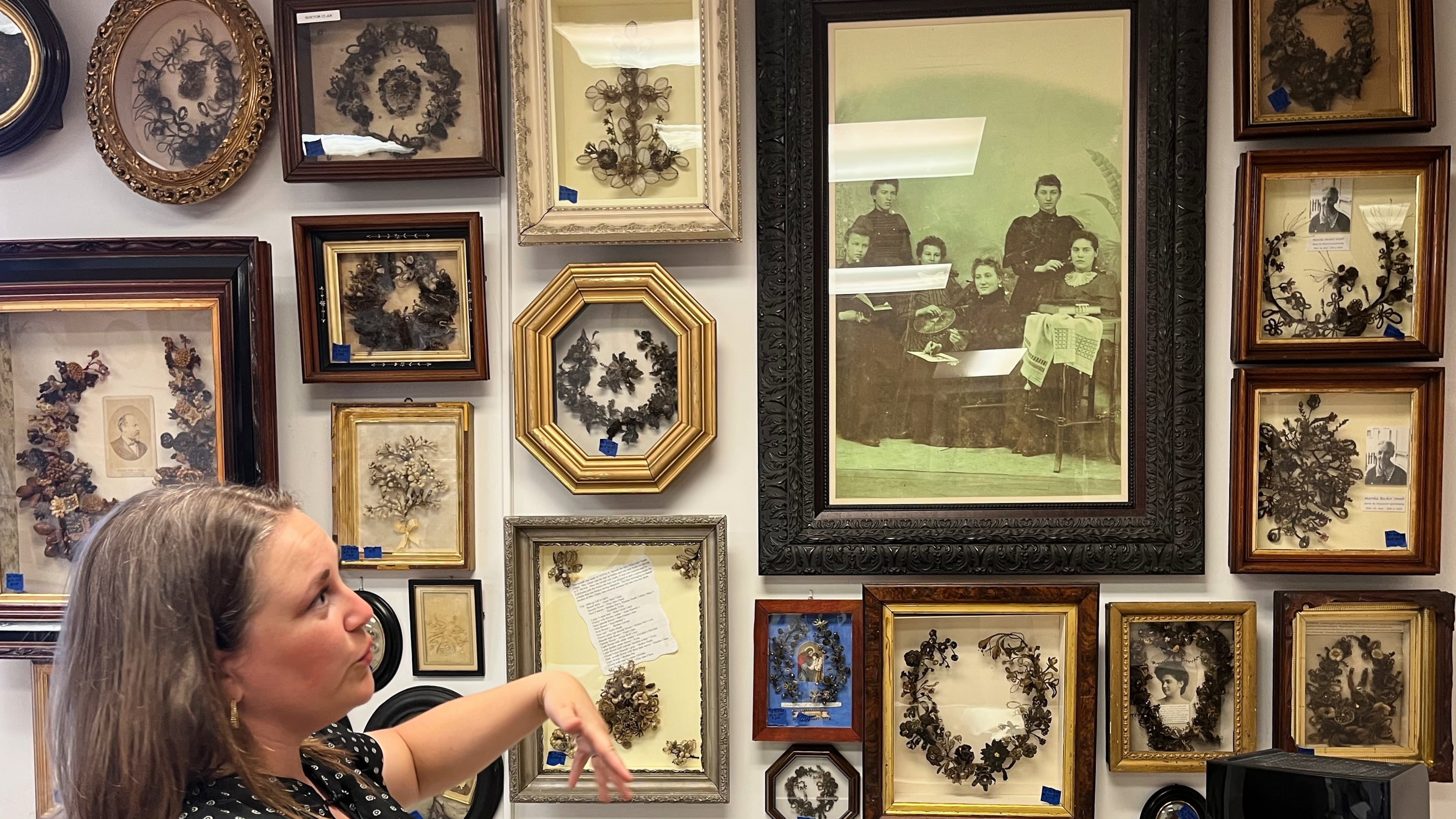 Lindsay Evans gestures to a historic photo of Victorian-era women weaving human hair into art, during a tour of Leila’s Hair Museum on Monday, Oct. 6, 2025, in Independence, Miss. (AP Photo/Heather Hollingsworth)