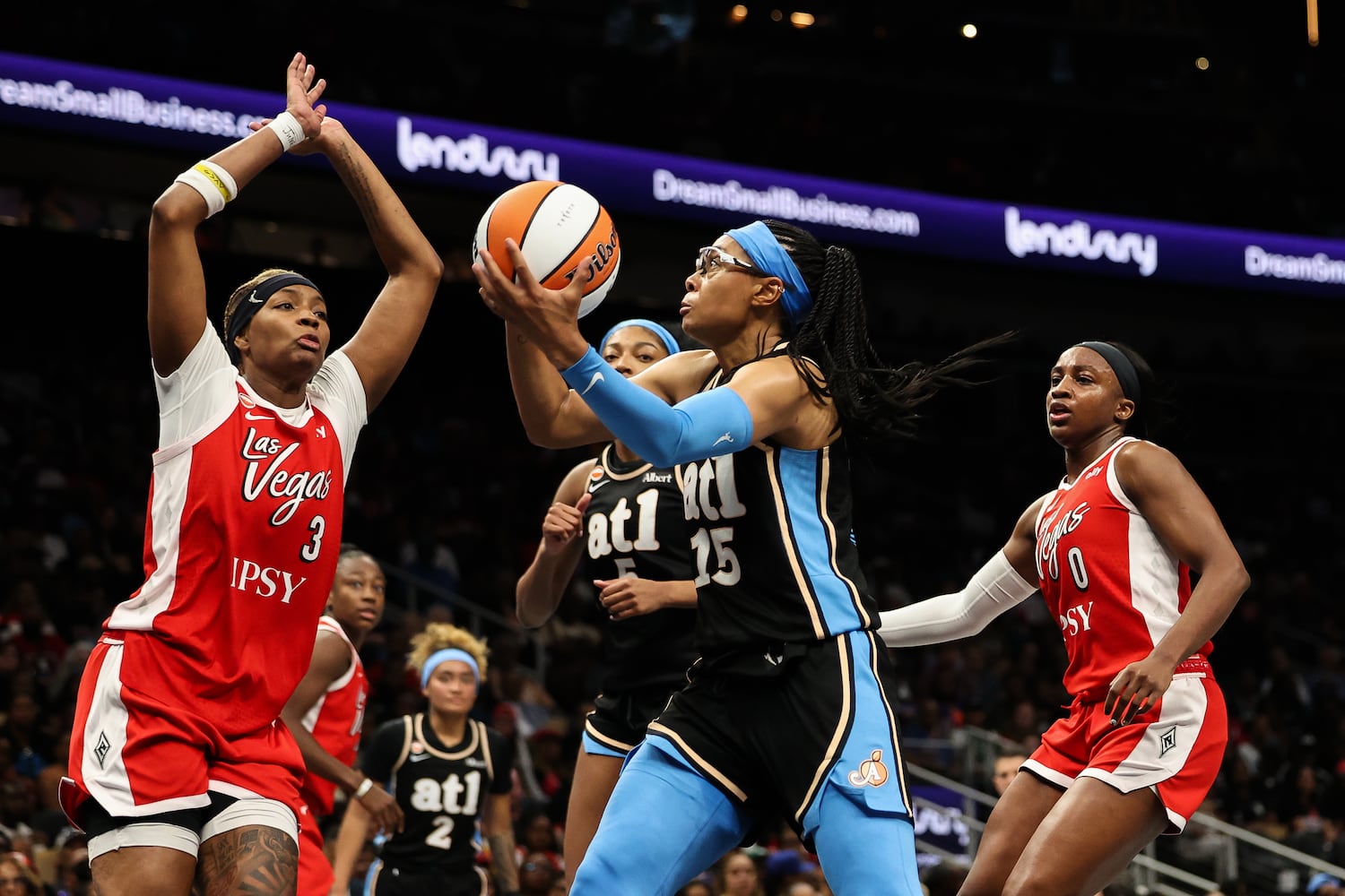 Dream guard Allisha Gray (center) shoots against Aces forward NaLyssa Smith (left) during the first half Sunday, May 17, 2026, at State Farm Arena in Atlanta. (Colin Hubbard for the AJC) 