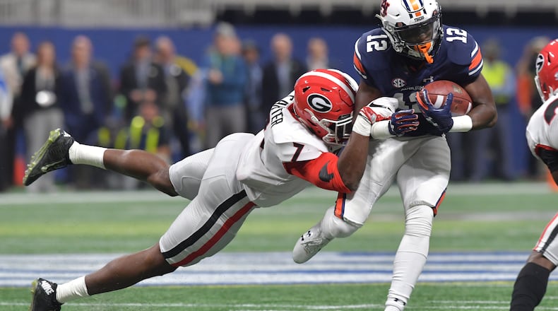 Georgia linebacker Lorenzo Carter (7) hangs onto Auburn Tigers wide receiver Eli Stove (12) during the SEC Championship Game at Mercedes-Benz Stadium, Dec. 2, 2017, in Atlanta.