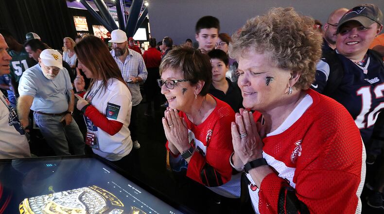 Falcons fans Sharon Vickery (from left) and Diane Page, both from Canton, take in the Super Bowl rings exhibit while Patriots fan Jesssalyn DiManno looks on while joining the thousands of football fans in town for the Super Bowl as they take in the pro football interactive theme park the NFL Experience on Thursday, Feb. 2, 2017, in Houston.