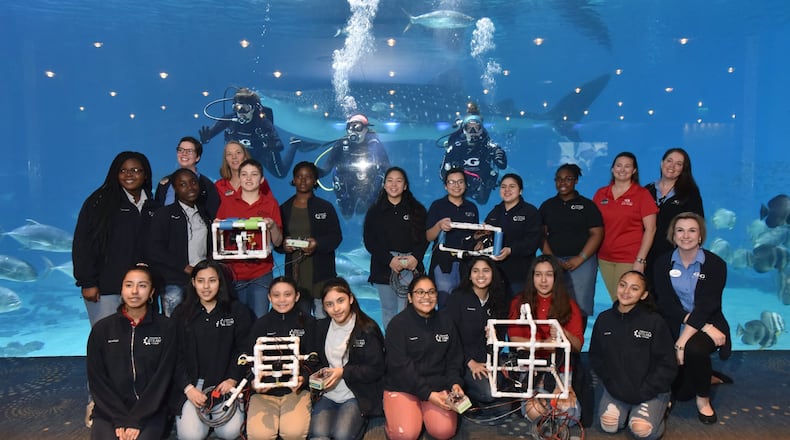 Students from Sweetwater Middle School and instructors pose with divers (from left) Susan Street, Lauren Schwitters and Kristen Binz for a group photograph during Girls Underwater ROV STEM Camp at Georgia Aquarium on Thursday, April 4, 2019. HYOSUB SHIN / HSHIN@AJC.COM