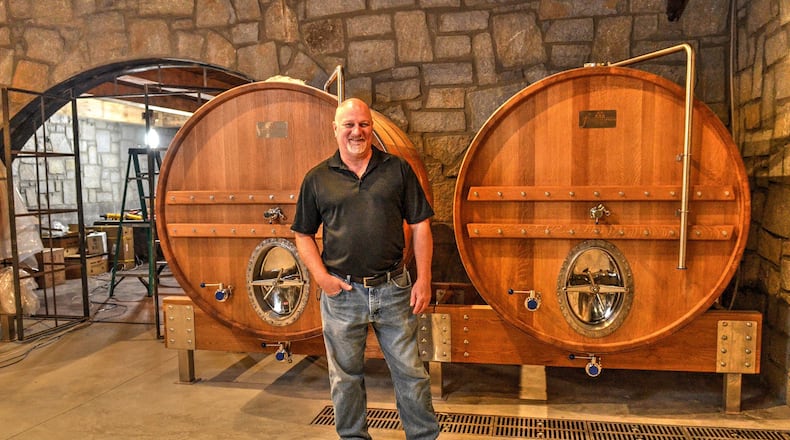 John “JR” Roberts, brewmaster at Bold Monk Brewing Co., stands in front of two oak foeders in the cask room. CONTRIBUTED BY CHRIS HUNT PHOTOGRAPHY