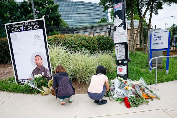 Centers for Disease Control and Prevention employees are shown placing flowers in honor of fallen DeKalb County police Officer David Rose, 33, outside the CDC headquarters on Sunday August 10, 2025. Officer Rose died in the line of duty while responding to a shooter who fired at the CDC on Friday.
(Miguel Martinez/AJC)