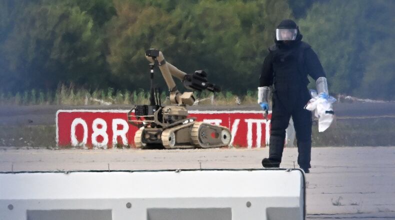 A forensic technician works alongside a bomb-disposal robot near a Ukrainian aircraft at Leipzig/Halle Airport, where a drone with an explosive device was found and a detonator was removed from the object, in Schkeuditz, Germany, Wednesday Aug. 5, 2026. (Hendrik Schmidt/dpa via AP)