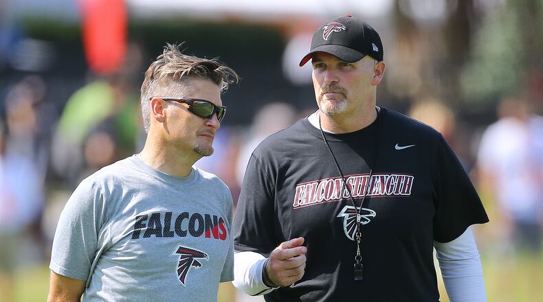 Falcons General Manager Thomas Dimitroff and head coach Dan Quinn confer on the first day of training camp on Friday, July 31, 2015, in Flowery Branch. Curtis Compton / ccompton@ajc.com