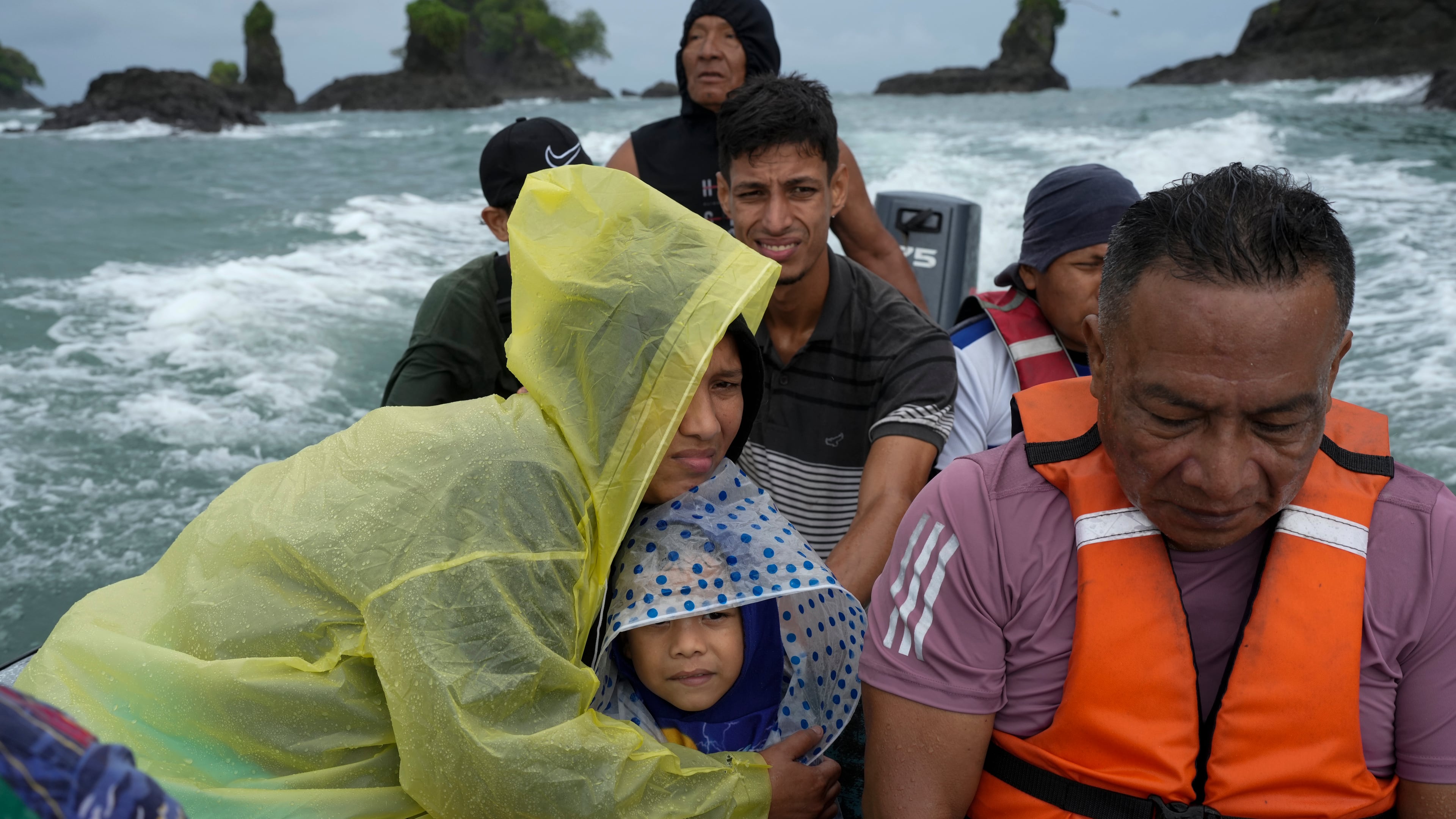 Venezuelan Mariela Gomez holds her son Mathias as they boat to shore after arriving on a larger cargo vessel in Jaque, on Panama's Pacific coast, Thursday, Sept. 18, 2025, during their journey south after giving up on reaching the United States. (AP Photo/Matias Delacroix)