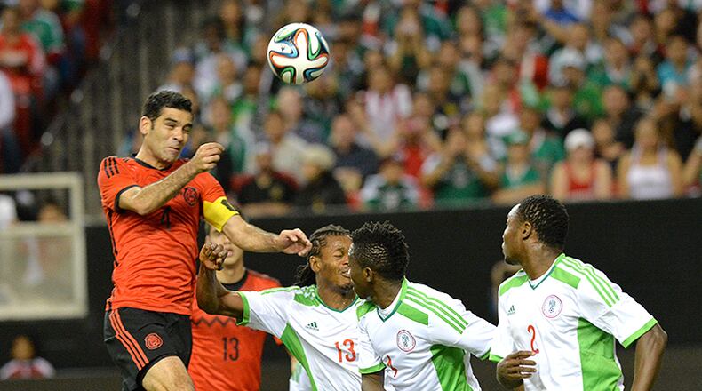 Mexico defender Rafael Marquez (left) heads the ball away from the Nigeria squad during their soccer friendly Wednesday at the Georgia Dome in Atlanta.