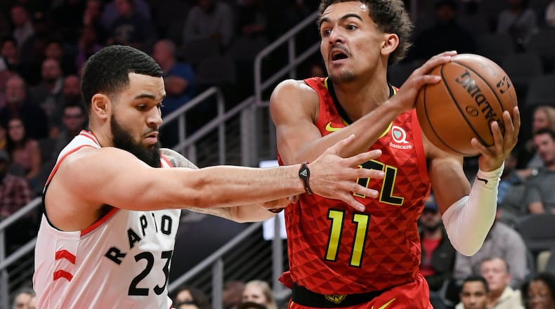 Hawks guard Trae Young (11) takes the ball into the lane as Toronto Raptors guard Fred VanVleet defends. (AP Photo/John Amis)
