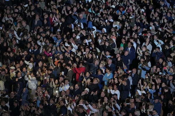 People react in St. Peter's Square at the Vatican after black smoke billowed from the chimney of the Sistine Chapel, where 133 cardinals are gathering on the first day of the conclave, indicating that a successor of late Pope Francis was not elected, Wednesday, May 7, 2025. (AP Photo/Markus Schreiber)