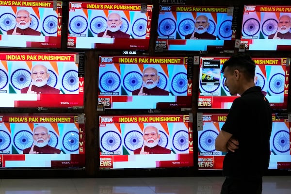 A man watches the live telecast of Indian Prime Minister Narendra Modi's speech on television screens at a shopping mall after 'Operation Sindoor' in Mumbai, India, Monday, May 12, 2025. (AP Photo/Rajanish Kakade)