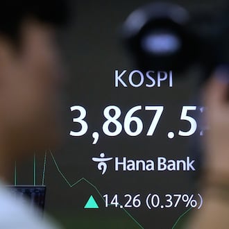 A TV camera man stands near a screen showing the Korea Composite Stock Price Index (KOSPI) at the foreign exchange dealing room of the Hana Bank headquarters in Seoul, South Korea, Monday, Nov. 24, 2025. (AP Photo/Ahn Young-joon)