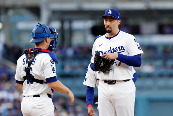 Los Angeles Dodgers' Blake Snell, right, gets a visit from catcher Will Smith during the second inning of a baseball game against the Atlanta Braves Wednesday, April 2, 2025, in Los Angeles. (AP Photo/Kevork Djansezian)