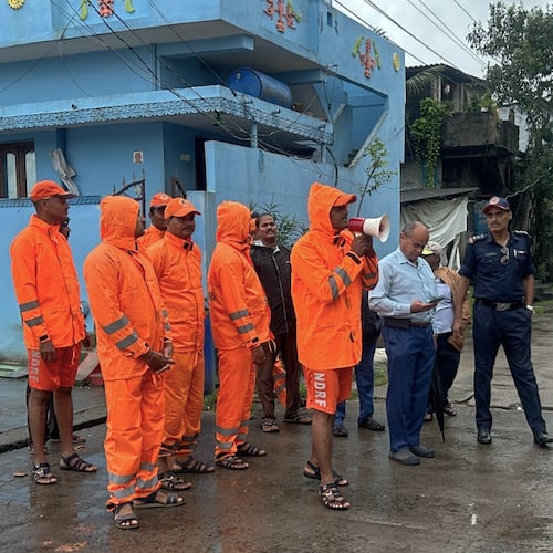 In this handout photo released by the National Disaster Response Force (NDRF), NDRF personnel warn residents of Cyclone Montha, in Yanam, in the Indian state of Andhra Pradesh, Monday, Oct. 27, 2025. (NDRF via AP)