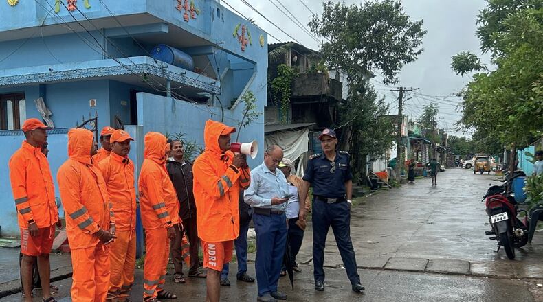 In this handout photo released by the National Disaster Response Force (NDRF), NDRF personnel warn residents of Cyclone Montha, in Yanam, in the Indian state of Andhra Pradesh, Monday, Oct. 27, 2025. (NDRF via AP)