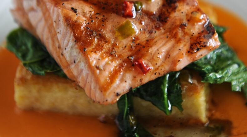 Grilled wild salmon with crispy cheddar grit cake, smoked tomato vinaigrette, jalapeno jam, country ham chip and local greens at Antebellum. (Contributed by Becky Stein)