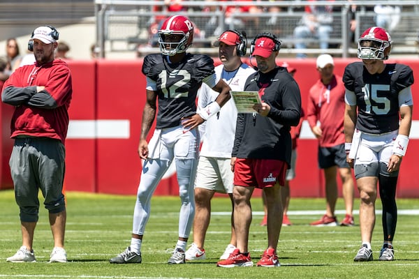 Alabama offensive coordinator Ryan Grubb, red shorts, stands with Alabama quarterback Keelon Russell (12) between plays during Alabama's A-Day NCAA college football practice and autograph session, Saturday, April 12, 2025, in Tuscaloosa, Ala. Alabama quarterback Ty Simpson (15) is also pictured. (AP Photo/Vasha Hunt)