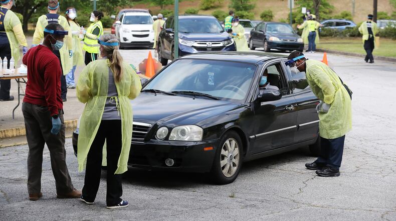050420 Decatur: Some of the more than two dozen specimen collection volunteers perform free COVID-19 tests at a pop-up site at the House of Hope on Monday, May 4, in Decatur. Pastors, local physicians, health ministers, and other community leaders united to encourage area residents to get tested with hundreds of motorists participating.    Curtis Compton ccompton@ajc.com