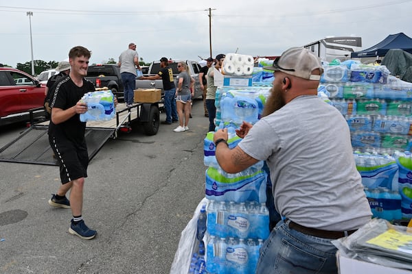 Volunteers deliver water to a command center at the London-Corbin Airport in London, Ky., Monday, May 19, 2025. (AP Photo/Timothy D. Easley)